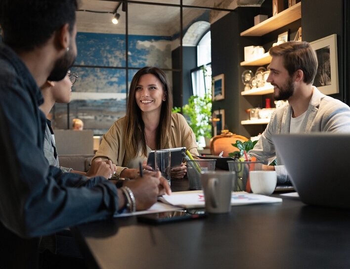 Titelbild Bachelor Personalmanagement Ein Team bespricht in moderner Umgebung gemeinsam Strategien zu Personalentwicklung und Zusammenarbeit.